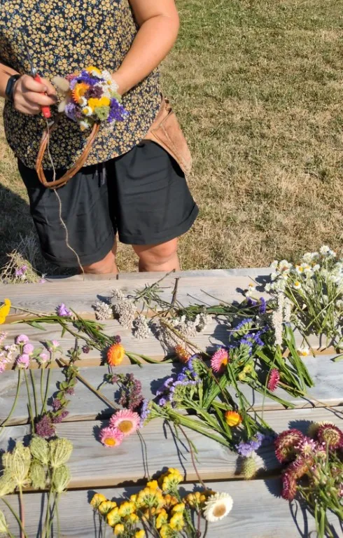 kathleen maakt droogbloemenkrans op picknicktafel.webp